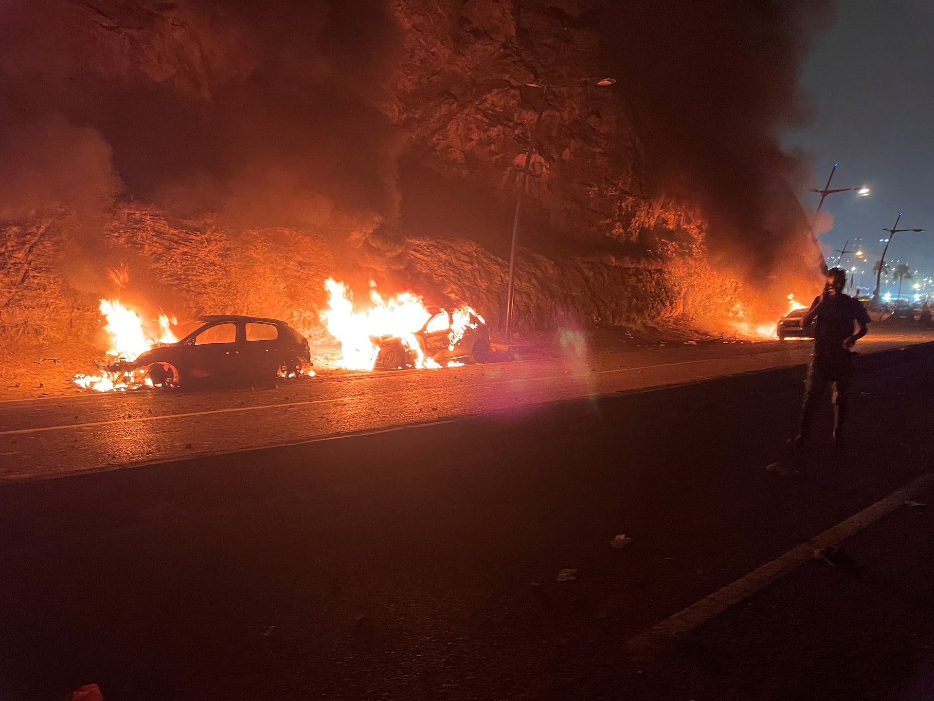 Several vehicles burn at night on the road in Fnideq near the Ceuta border